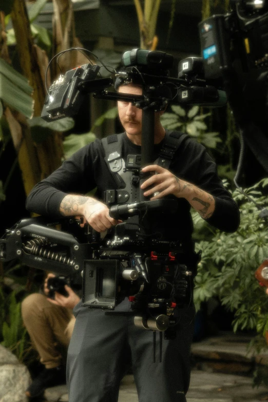 a man in black shirt holding onto camera equipment