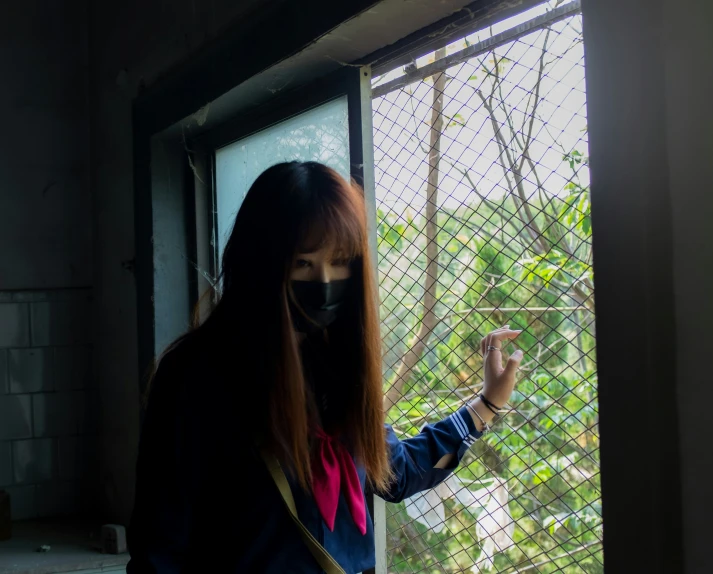 a woman in a mask looking out of a window