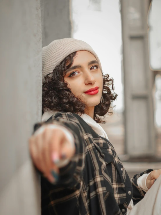 an attractive young lady leaning on the wall