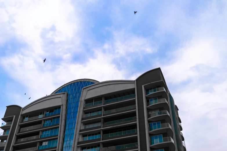 a high rise building has blue balconies on top