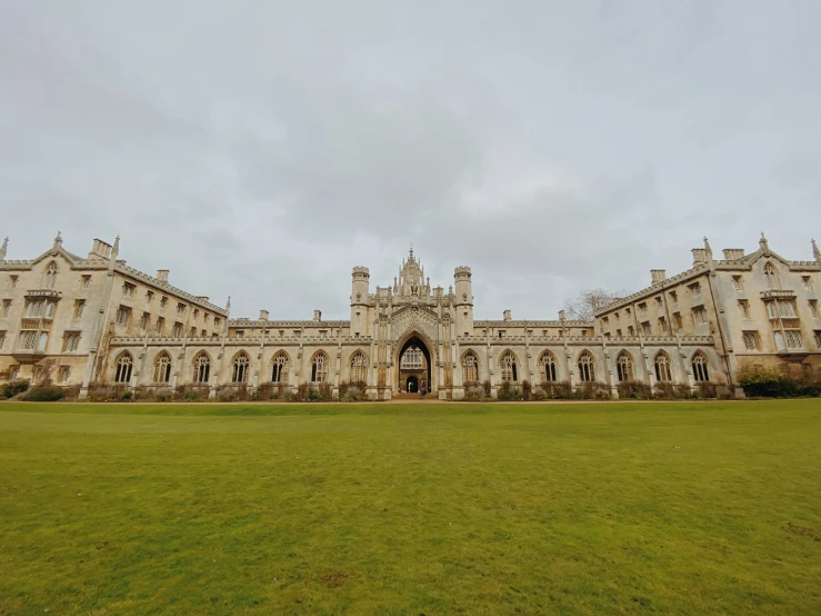 a big mansion on the grass has two large windows