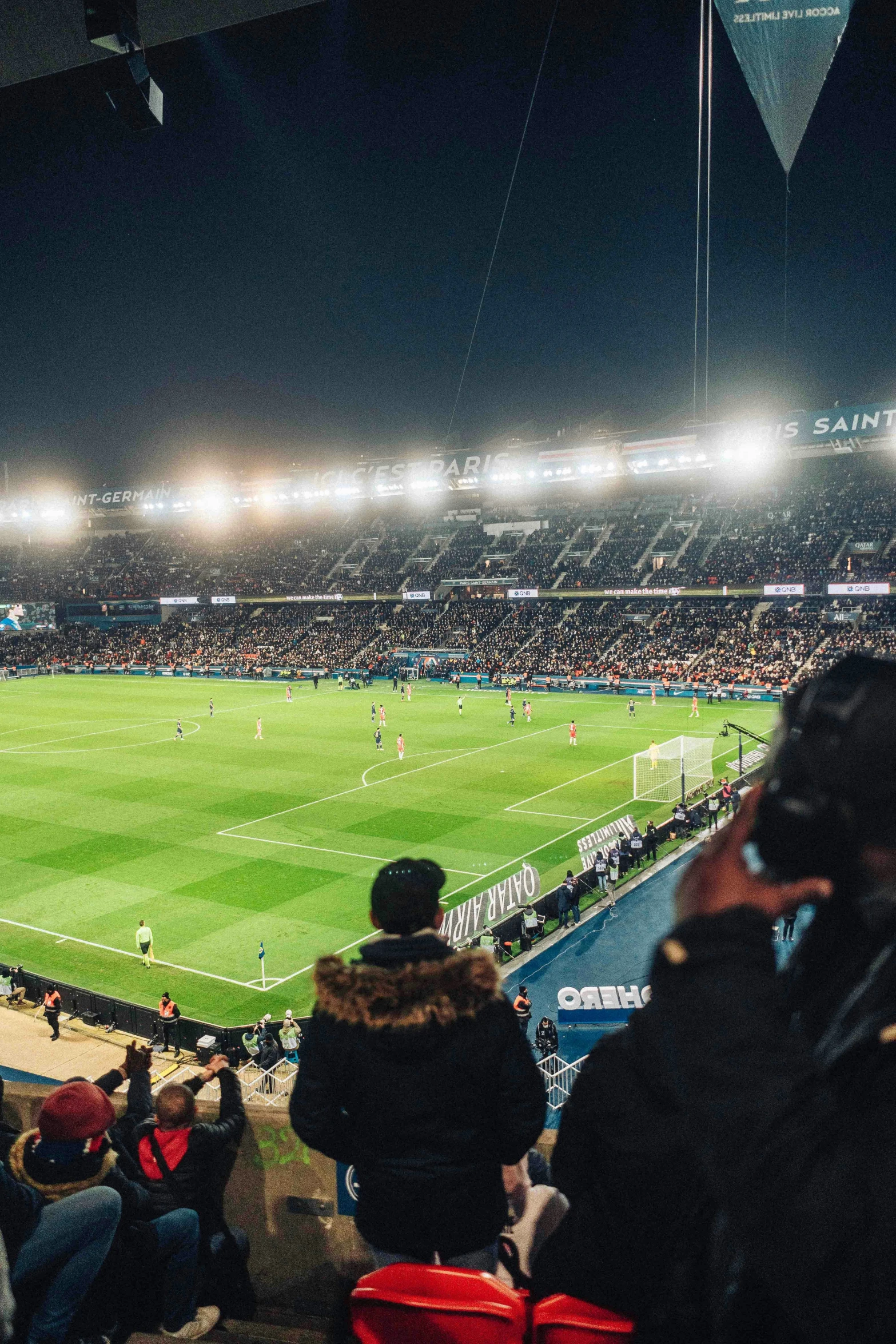 many people sitting on a stadium, watching a soccer match