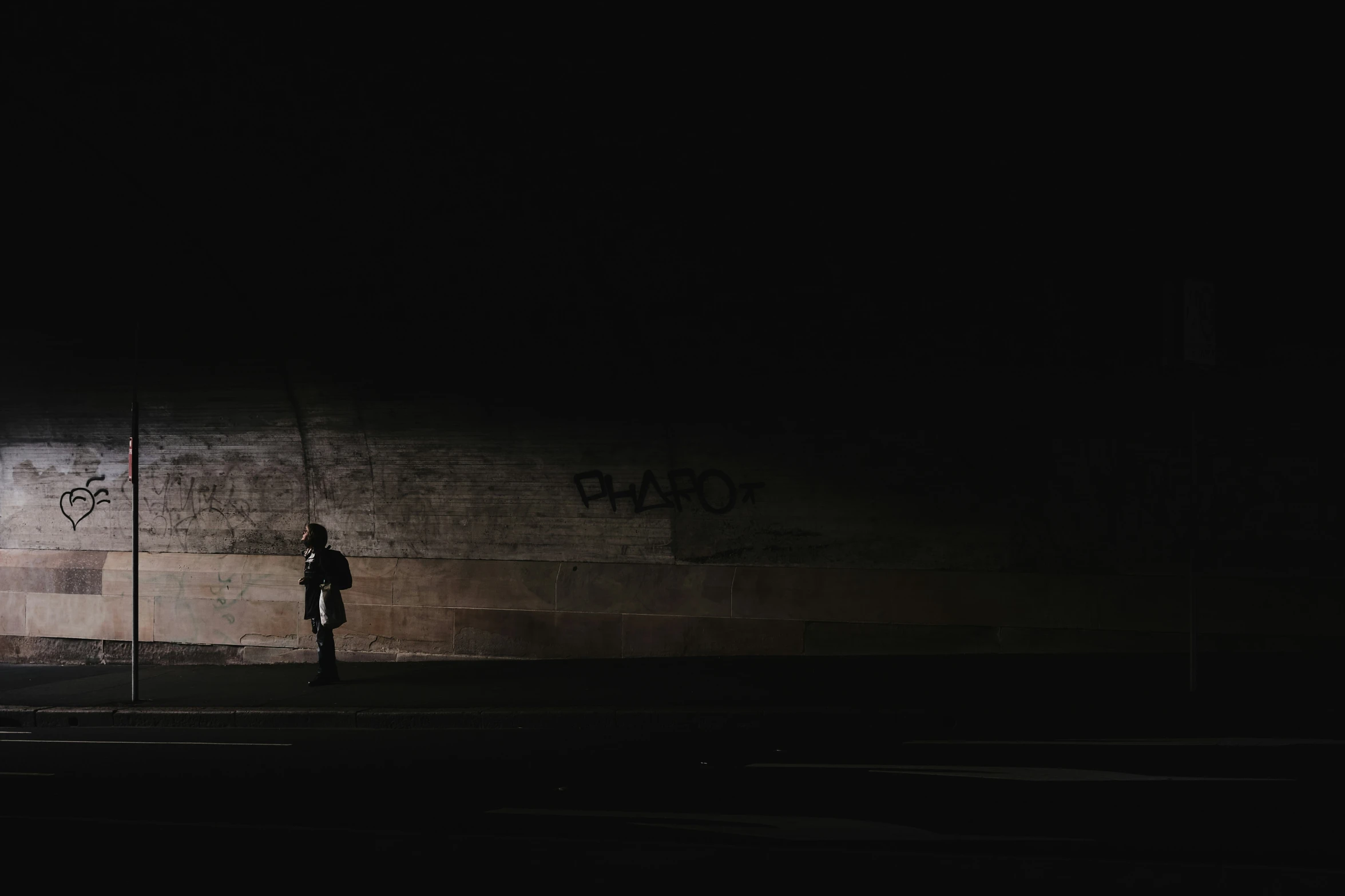 a person is standing in front of the wall at night