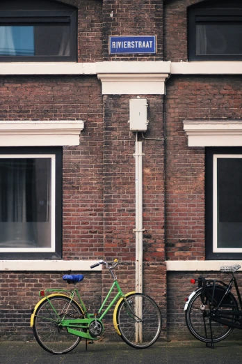 two bikes sitting next to each other against a brick building