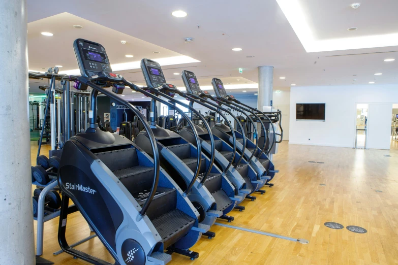 rows of stationary fitness machines in an office gym