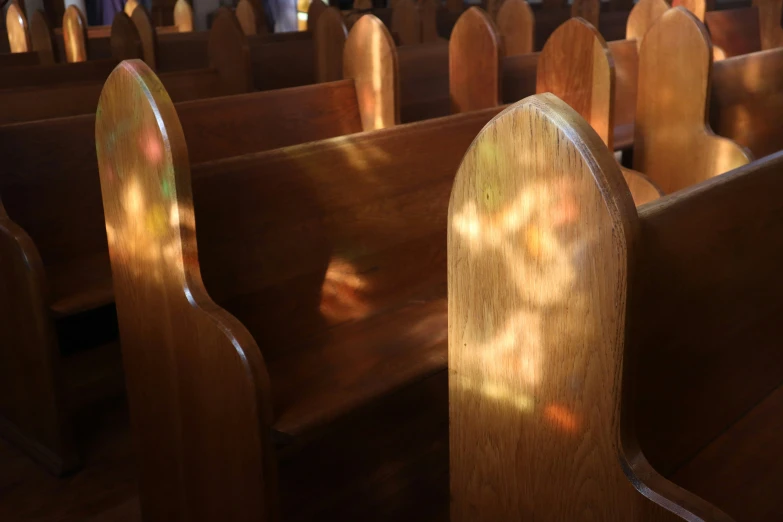 a church pew with wooden back and silver cross marks