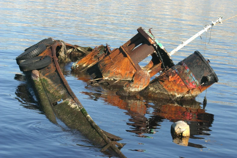 a rusted metal object in water with a rod
