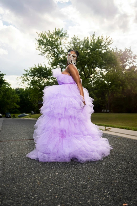 a woman in a gown standing in the street