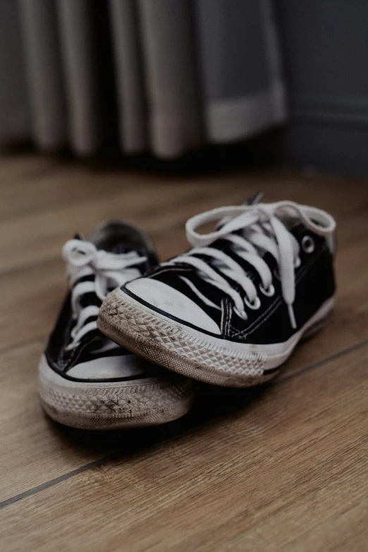 a pair of black and white sneakers are on the floor