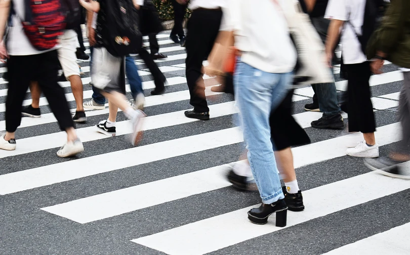 several people walking across a crosswalk in the city