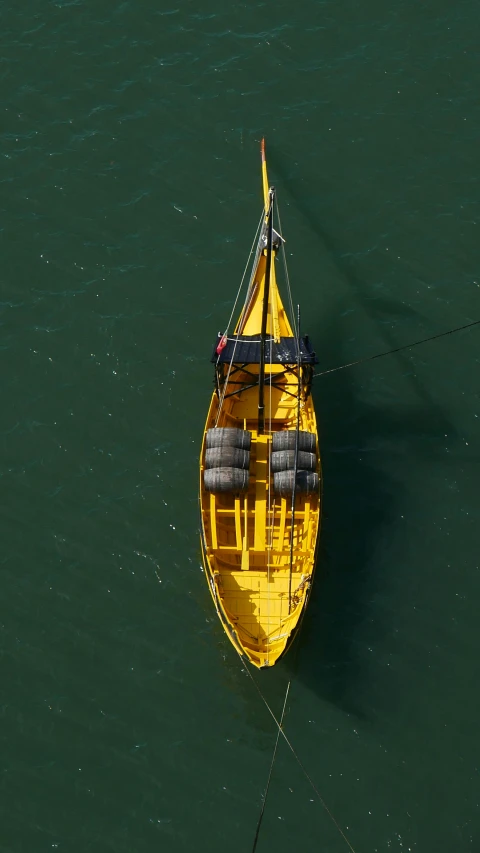 a yellow boat floating across a body of water