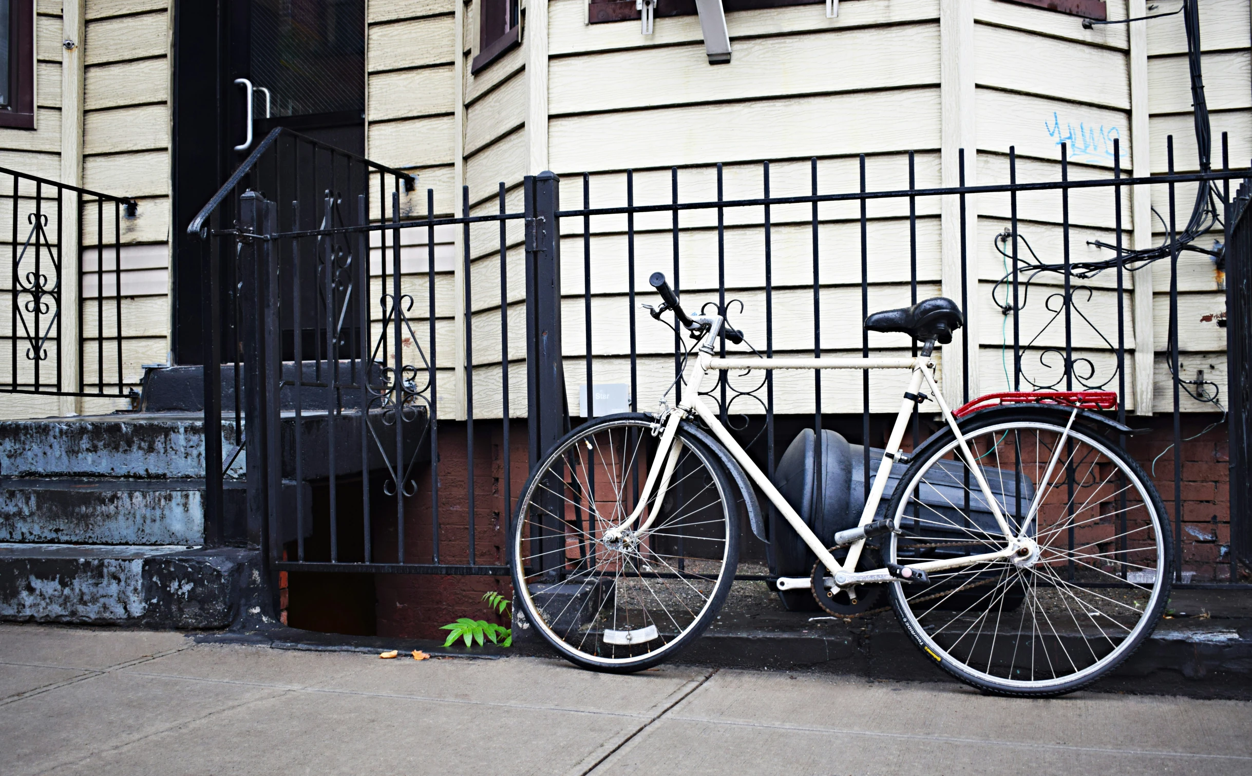 the bike is locked up outside on the sidewalk