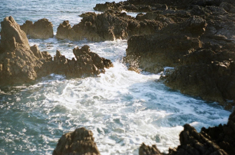 an ocean view with rocky shore and waves