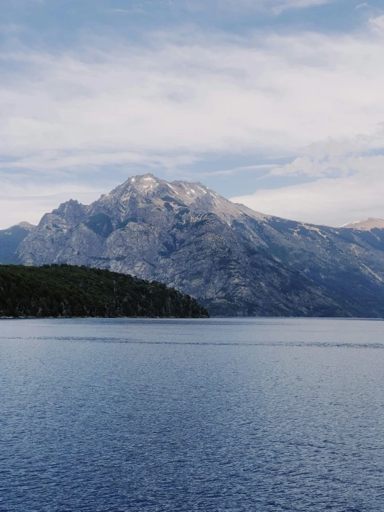 a lake surrounded by mountains under a blue sky