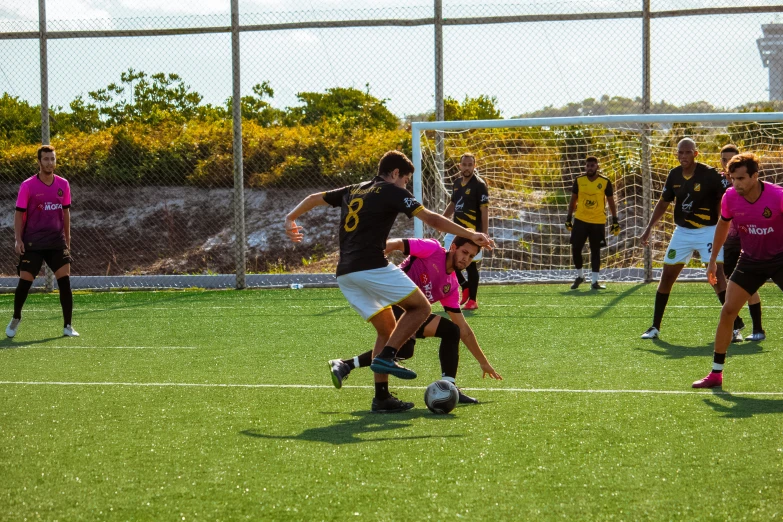 soccer player on field with ball, while other players watch