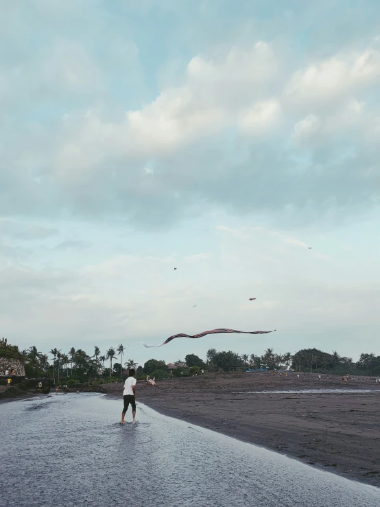 a person walking along a street flying a kite