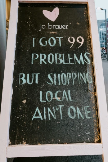 a sign in front of a building that says, i got 99 problems but shopping local isn't one