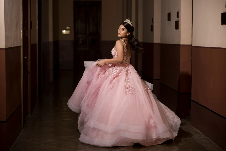 a woman in a pink dress standing inside