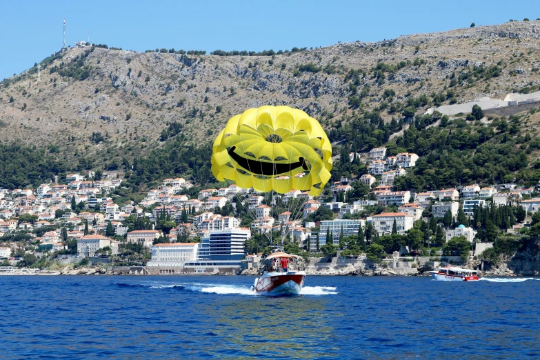 large smile balloon being flown by a water skier