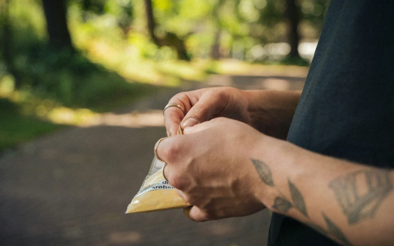 a man holding soing in his hands and tattoos