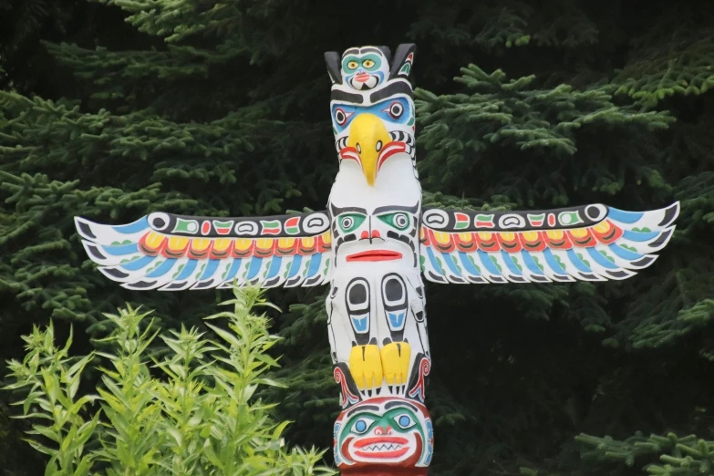 a totem bird is on display in front of some trees