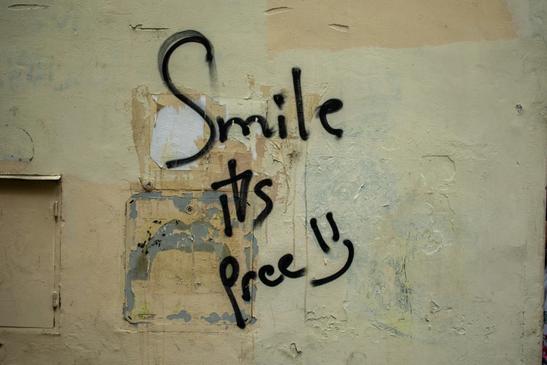 graffiti written on the wall says smile its a piece