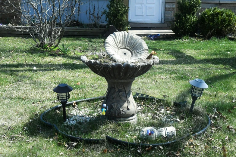 a decorative fountain in the middle of a lawn