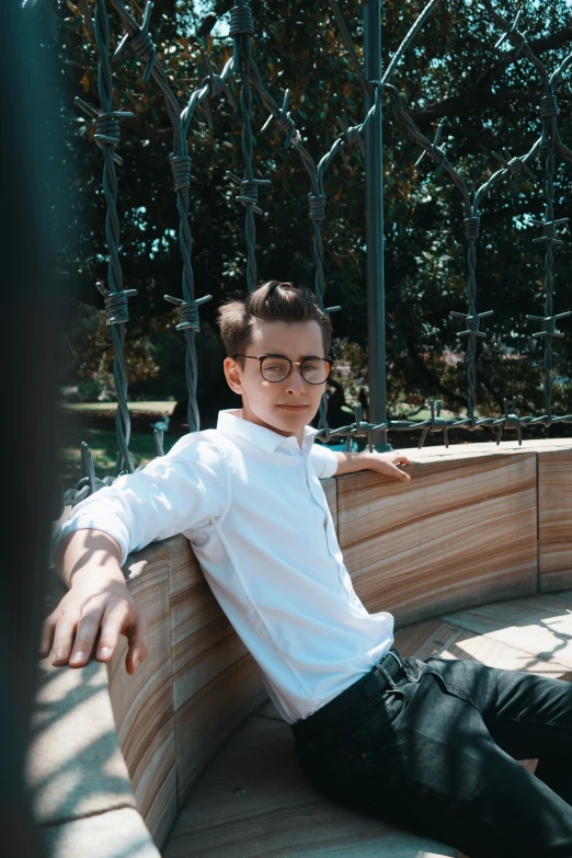 a man with glasses sitting in a bench