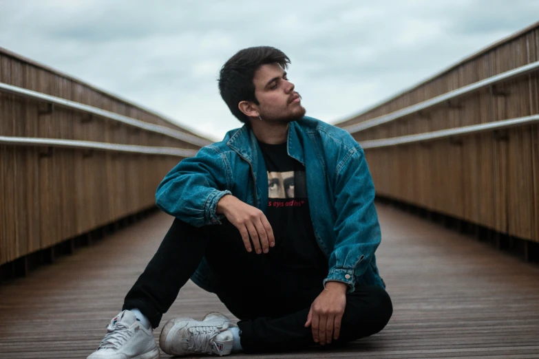 a man is sitting on the bridge with a watch