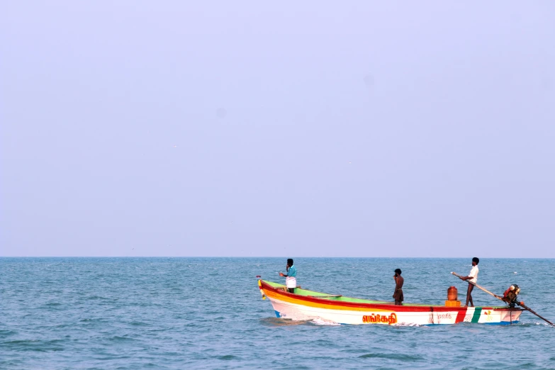 several people in a boat at sea, and two are standing on the bow