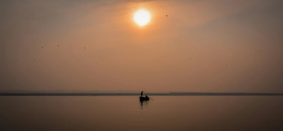 a person on a small boat on a calm river