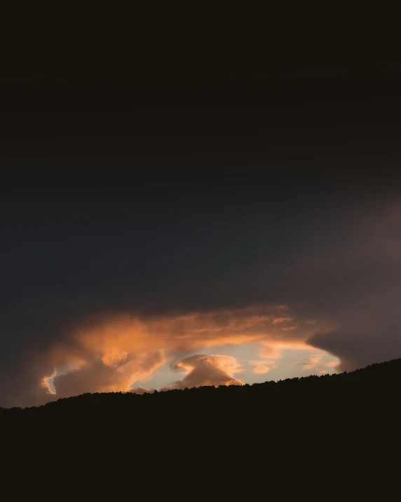 a black sky with white clouds and some oranges