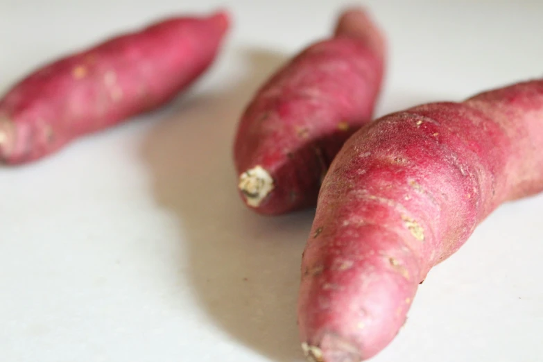 two fresh red potato's lying on a table