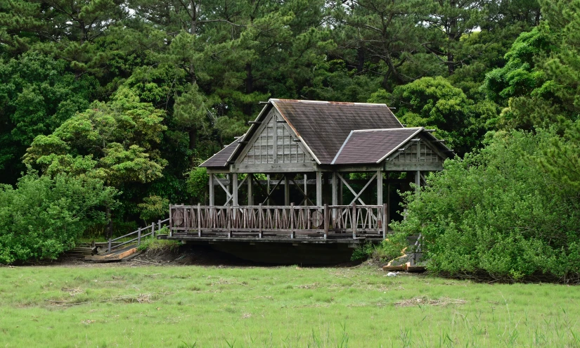 an old wooden building sits in front of a lot of trees