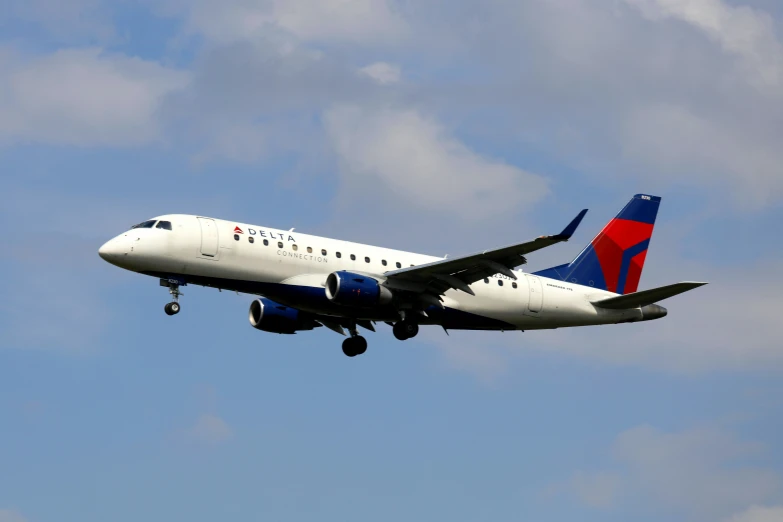 a delta airlines plane is in the air with it's landing gear down