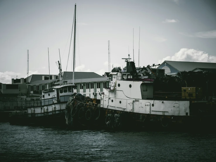 an old ship docked at a wharf on water