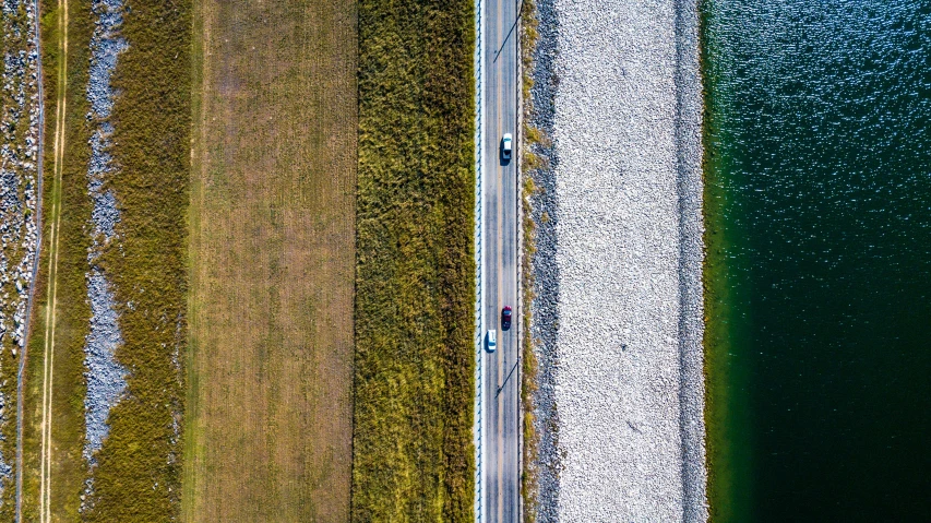 a road on the side of a large lake