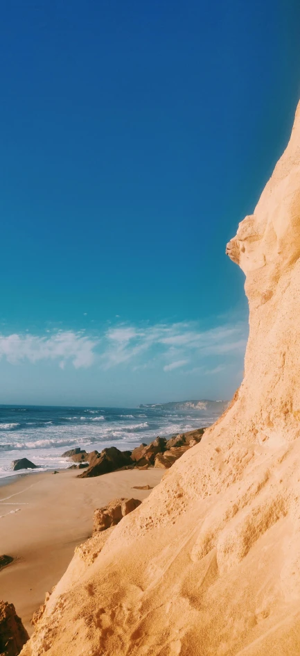 some waves water sand and a blue sky