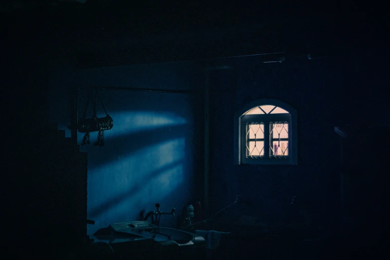 a bathroom in a dark room with light coming from the window