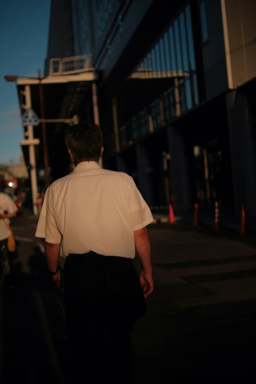 a man in a shirt walking down the street