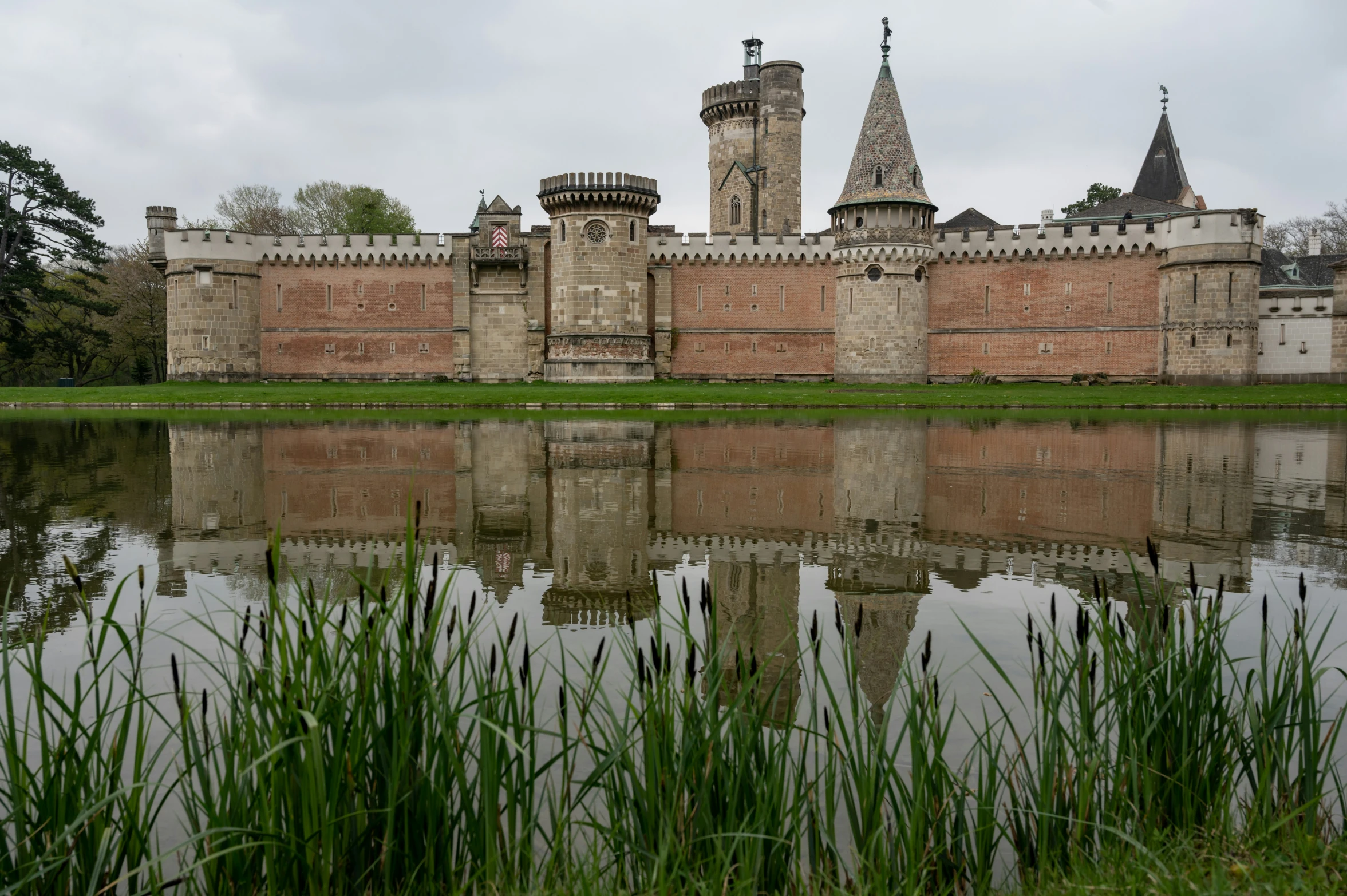 an old castle with its moat reflecting in the water