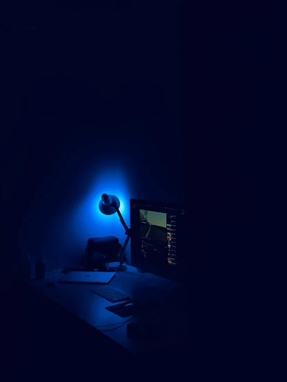 computer screen and keyboard illuminated in blue