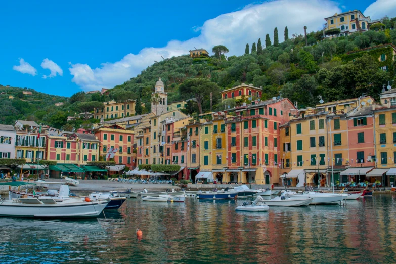 many boats on a body of water with buildings in the background