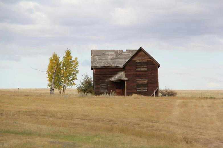 a very old house with no windows in the middle of the field