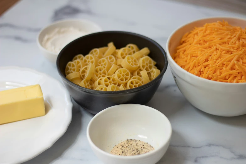 this bowl has a cheese sandwich and two smaller bowls with cheese on top