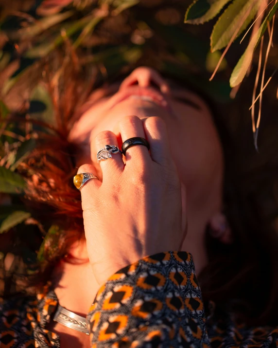 woman covering her eyes under some leaves