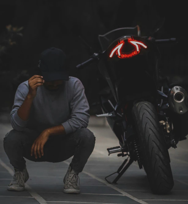 man crouched in the street touching his hand with an eye