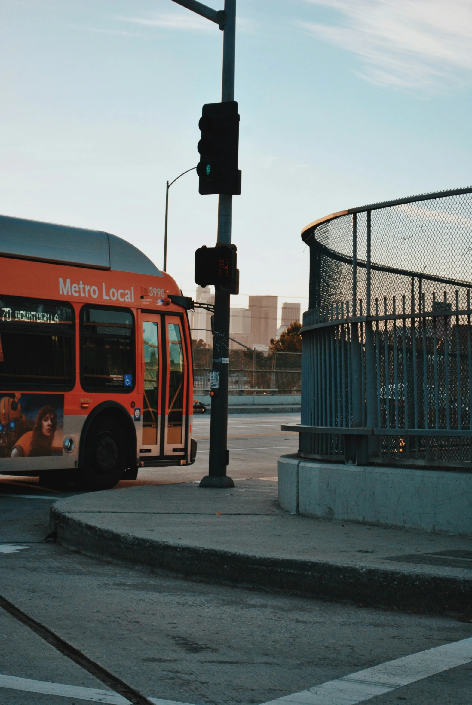 a large orange bus stopped at an intersection