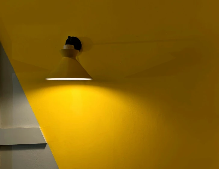 a yellow wall with an illuminated light on it