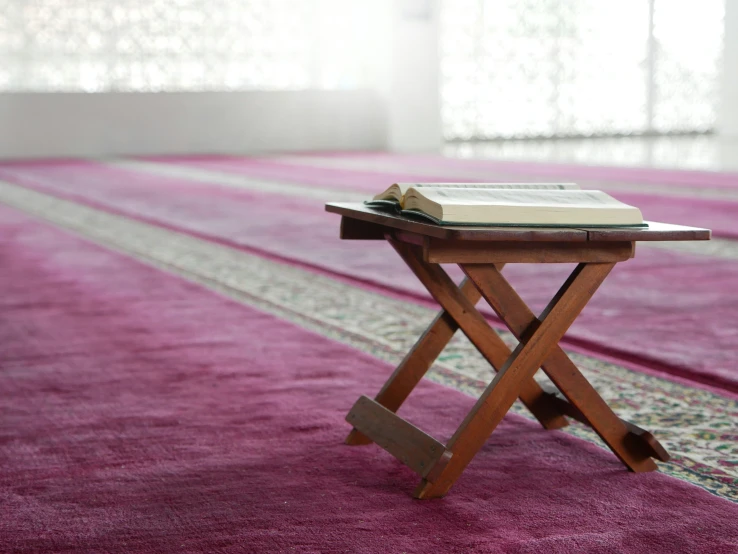 the small table is set on the carpet with a book on it